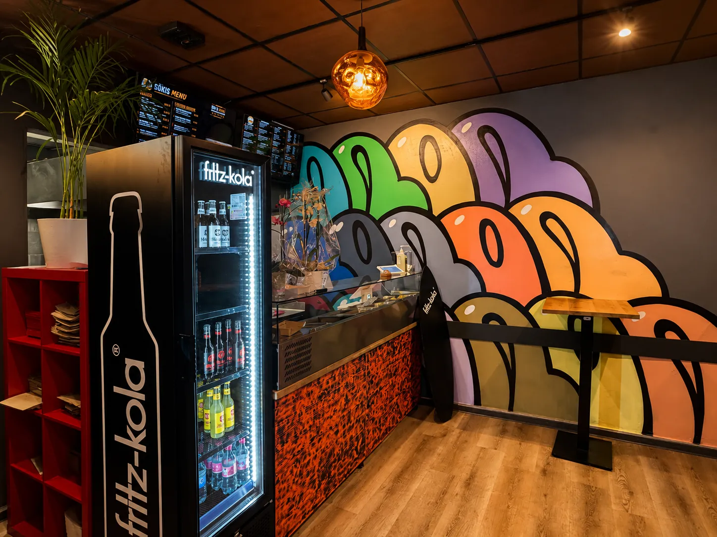 Theke mit Gökis-Neonschild, Fritz-Kola-Kühlschrank und Graffiti